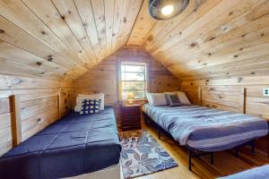 1 dormitorio con 2 camas en una cabaña de madera en Maggie's Lakeside Cottage en Wakefield