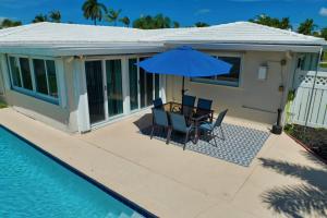 龐帕諾比奇的住宿－Ariel Beach Cottage，庭院配有桌椅和遮阳伞。