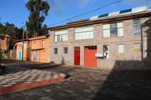 ein altes Gebäude mit roten Türen auf einer Straße in der Unterkunft LOVELAND AMANTANI LODGE - Un lugar encantado in Ocosuyo