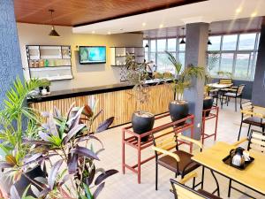 a restaurant with tables and chairs and plants at Ebenezer Hotel Apartments in Kigali