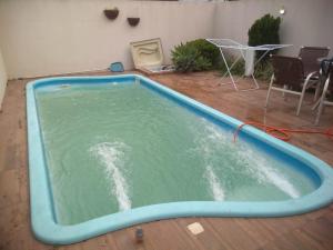 uma grande piscina de água num quarto com cadeiras em Sobrado Oktober com Piscina em Santa Cruz do Sul