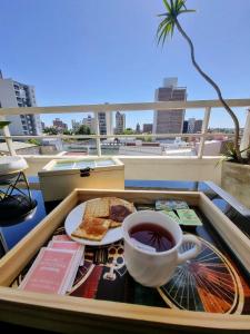 taca z jedzeniem i filiżanka kawy na balkonie w obiekcie Paraná Confort w mieście Paraná