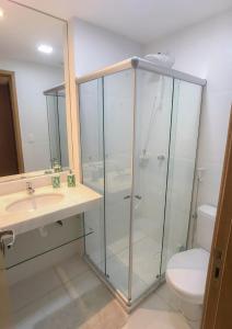 un bagno con doccia in vetro e WC di Flat Guarajuba, Charmoso Porto Smeralda a Guarajuba