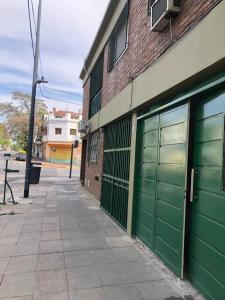 un edificio con porte verdi per garage su una strada di King & Queen a Buenos Aires