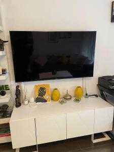 a large flat screen tv on a white cabinet at Modern apartment with garden in Antwerp, 15min from City center in Antwerp