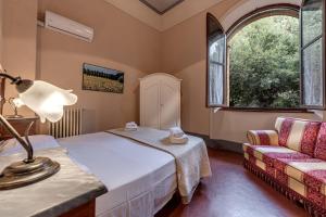 ヴォルテッラにあるAppartamenti Villa Mascagniのベッドルーム(ベッド1台、ソファ付)