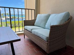 NazarethにあるSapphire Beach Villa Ocean and Marina Viewのバルコニー(テーブル付)に座る籐のソファ