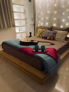 ein großes Bett mit zwei Tassen darüber in der Unterkunft Casa - By Great Impressions in Pune