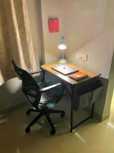 a desk with a chair and a laptop on it at Casa - By Great Impressions in Pune