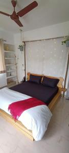 um quarto com uma cama grande e um cobertor vermelho em Casa - By Great Impressions em Pune
