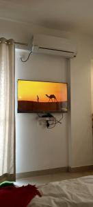 einen TV, der an einer Wand in einem Schlafzimmer hängt in der Unterkunft Casa - By Great Impressions in Pune