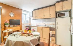 eine Küche mit einem Tisch und einem weißen Kühlschrank in der Unterkunft 1 Bedroom Lovely Home In Jubrique in Jubrique