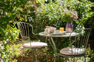 un tavolo con una tazza di tè e un vaso di fiori di Hotel des Grandes Ecoles a Parigi