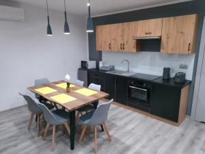 a kitchen with a wooden table and chairs in a room at Dom gościnny 4JAWA I in Tuczempy