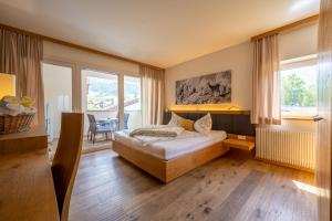 ein Schlafzimmer mit einem Bett und einem großen Fenster in der Unterkunft Residence Sägemühle in Prad am Stilfserjoch
