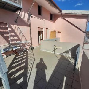 ein Schatten einer Person, die neben einem rosa Gebäude steht in der Unterkunft Appartamento luminoso e spazioso al primo piano in Capoterra