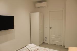 a white room with a white door and a television at B&B San Luca in Bologna