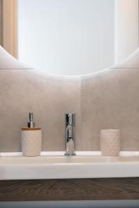 a sink with two faucets and two cups on it at Kalopsia Home in Rethymno Town