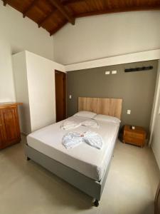 a bedroom with a large bed with white sheets at ApartaHotel Los Naranjos in Apartadó