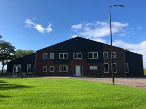 een groot zwart gebouw met een grasveld vooraan bij Mysa in Deurne