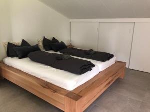 een groot bed met zwarte kussens erop bij Mysa in Deurne