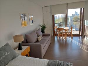 马德普拉塔EXCELENTE y completisimo monoambiente con cochera的带沙发和桌子的客厅