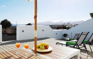 a table with two glasses of orange juice and fruit at Typical Canarian house with fabulous sea views in Tías