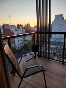 a chair on a balcony with a view of a city at EXCELENTE y completisimo monoambiente con cochera in Mar del Plata