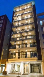 a tall building with lights on the side of it at EXCELENTE y completisimo monoambiente con cochera in Mar del Plata