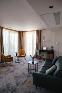 a living room with a couch and chairs and a piano at City Hotel Dubrovnik in Dubrovnik