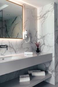 a bathroom with a sink and a mirror and towels at City Hotel Dubrovnik in Dubrovnik