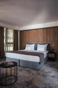 a bedroom with a large bed and a table at City Hotel Dubrovnik in Dubrovnik