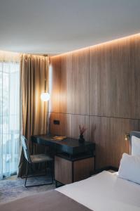 a bedroom with a desk with a bed and a chair at City Hotel Dubrovnik in Dubrovnik