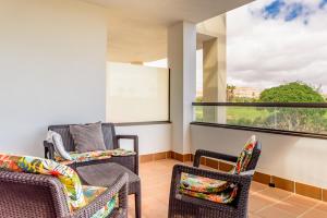 a balcony with two chairs and a window at Modern apartment in residential complex with pools in Costa de Antigua