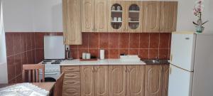 una cucina con armadi in legno e frigorifero bianco di Apartman Katica a Tivat
