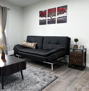 a living room with a black couch and a table at Anchorage midtown apartment- Wyoming 1 in Anchorage