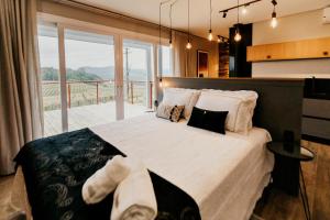 本图贡萨尔维斯Vista Vigneti Albergo & Vino - Vale dos Vinhedos的一间带大床和大窗户的卧室