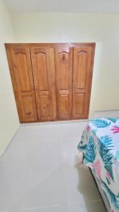 1 dormitorio con armarios de madera y 1 cama. en Jarabacoa Mountain Views, en Jarabacoa