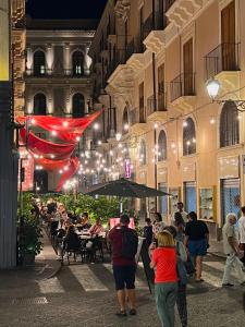 um grupo de pessoas andando por uma rua à noite em CiuriCiuri Home Appartamento storico nel centro di Catania em Catânia