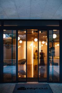 a building with glass doors with a person walking outside at City Hotel Dubrovnik in Dubrovnik