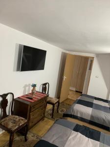 a bedroom with a bed and a tv on the wall at Cheerful 3-Bedroom Getaway in Zărneşti