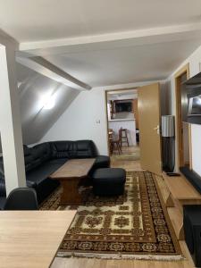 a living room with a black couch and a table at Cheerful 3-Bedroom Getaway in Zărneşti