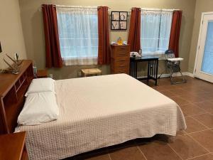 Un dormitorio con una cama, un escritorio y ventanas. en Guest Home on Lake Godstone, en Jacksboro