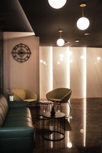 a room with a couch and two tables and a clock at City Hotel Dubrovnik in Dubrovnik