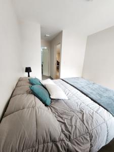 una camera da letto con un grande letto con cuscini blu e bianchi di DPTO ZONA BUEN PASTOR a Córdoba