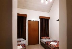 Kleines Zimmer mit 2 Betten und einer Tür in der Unterkunft The Zillion Builders Pavilion in Lipa