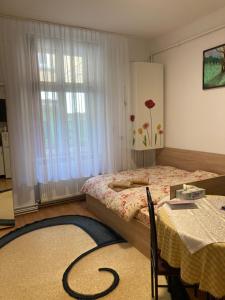 a bedroom with a bed and a table and a window at House Centrul Istoric in Sibiu