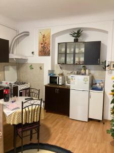 a kitchen with a table and a white refrigerator at House Centrul Istoric in Sibiu