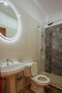 y baño con aseo, lavabo y espejo. en July AirBnB en Lower Princeʼs Quarter