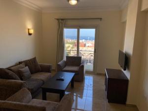 uma sala de estar com um sofá, uma mesa e uma televisão em Bahga Palace 5 Residential Apartments em Hurghada